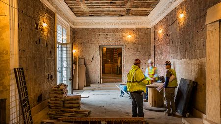 Skilled construction team discussing plans in a room with exposed brick