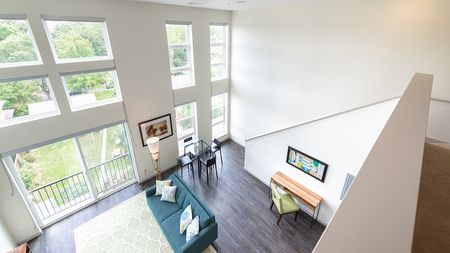 2nd Level Loft Down to Open Living Area with Wall of Windows
