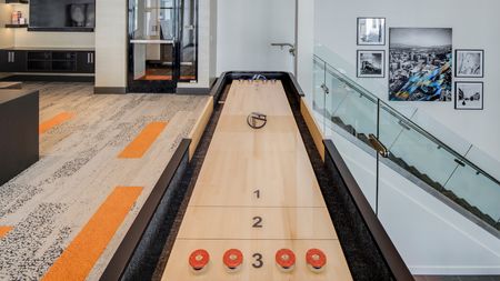 Resident Lounge featuring a Shuffleboard table next to glass encased stairway