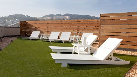 Rooftop lounge seating on lush turf landscape overlooking mountains