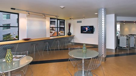 Resident lounge with bar area and table and chair seating