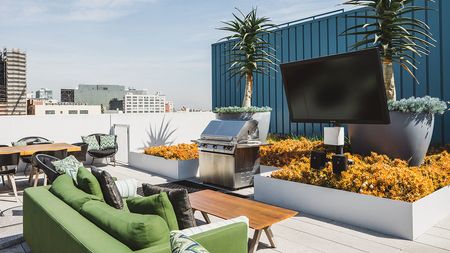 Social seating on terrace with large flat screen television and grilling station