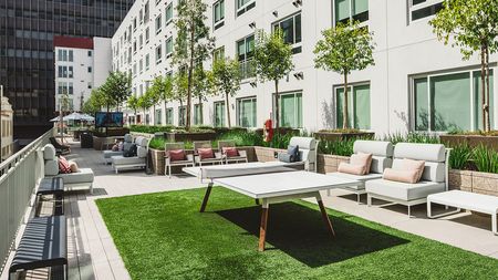 Terrace access ping pong table on turf grass and outdoor seating