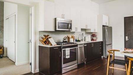 Well appointed kitchen featuring espresso lower cabinetry and white upper cabinetry