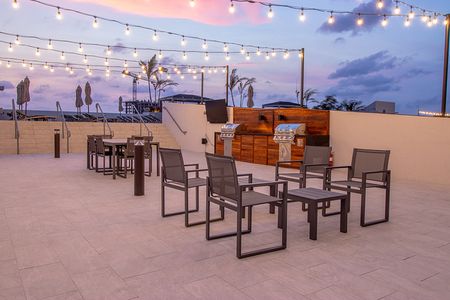Roof top grilling area with social seating and string lights