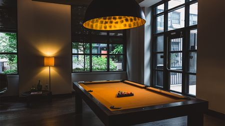 Billiards table beneath large tin light