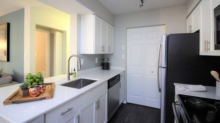 Elegant Kitchen featuring Quartz Countertops and White Cabinetry at Alister Town Center Columbia apartments.