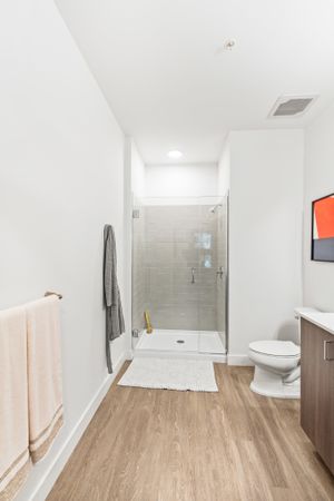 Large glass-enclosed showers and large bathrooms in a Modera Framingham apartment.