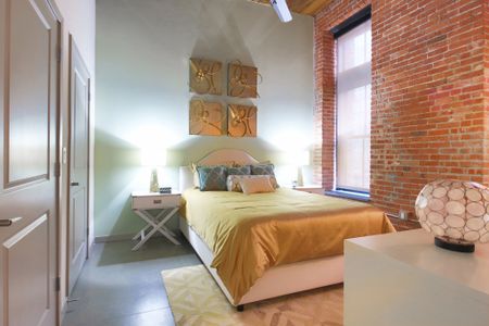 Exposed Brick from the Original Building Enhances the Bedroom at Modera Lofts apartments.