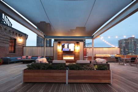 Roof Top Deck with Entertainment Seating around a Wall Mounted Television at Modera Lofts apartments.