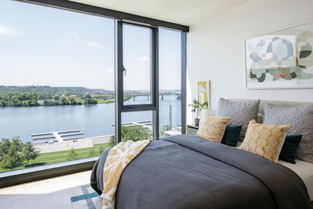 Master Bedroom with Floor to Ceiling Windows Overlooking Lush Landscape and Water