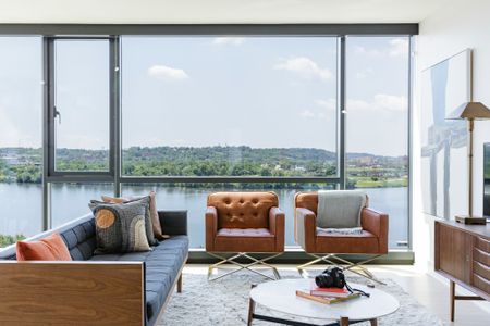Floor to Ceiling Windows in the Living Room Overlooking Lush Landscape and the Water
