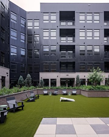 outdoor courtyard with seating and cornhole game modera art park apartment homes for rent in denver colorado
