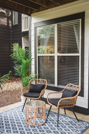 patio with two chairs in front of window at alister lake lynn apartment homes for rent in raleigh north carolina