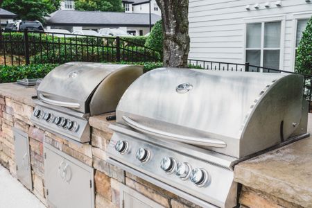 bbq area with two grills at alister lake lynn apartment homes for rent in raleigh north carolina