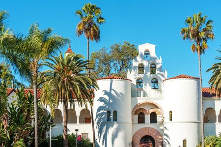 Photograph of a mission building near out apartments in San Diego, featuring palm trees and white walls.
