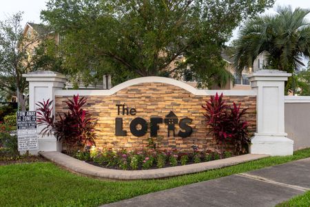 The Lofts apartments in Orlando, FL entrance sign, featuring a stone masonry wall with "The Lofts" logo on it.