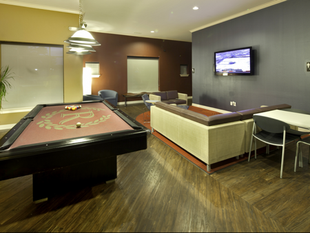 Pool table, seating area, and flat screen TV in the game room at The Reserve on West 31st