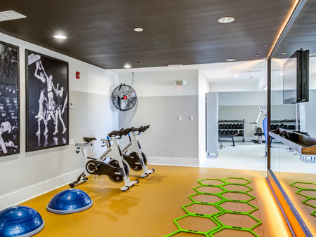 Gym at our apartments in Morgantown, WV, featuring spin bikes, balance balls, and a wall covered in mirrors.