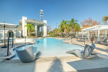 The pool lounge at our apartments for rent in Orlando, Florida, featuring beach chairs, umbrellas, and ping pong table.