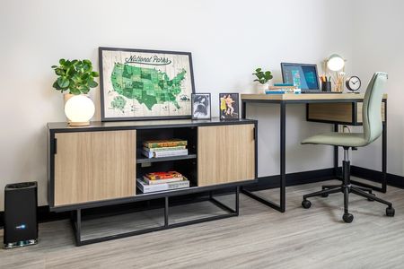 Model apartment highlighting the entertainment stand, desk, and chair