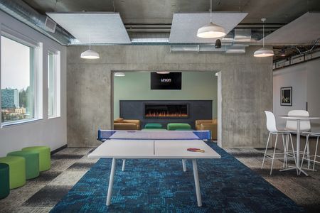 Game lounge with ping pong table and comfortable seating area in the background