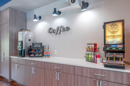 The coffee station at our student apartments near Penn State, featuring two coffee machines and wood grain cabinetry.