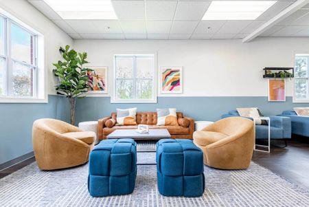 Resident lounge at our student apartments near Syracuse University, featuring cushion chairs with desks.