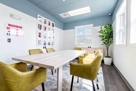 The conference room at our student apartments in Syracuse, featuring a conference table surrounded by chairs.