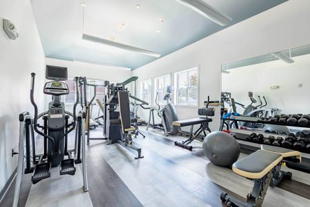 The fitness center at our apartments for rent in Syracuse, featuring treadmills and windows with a view.