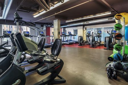 Second story of the fitness center with treadmills, ellipticals, stationary bikes, stair climber, and medicine balls