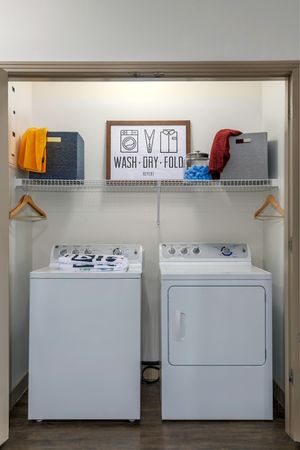 Model apartment laundry closet with full size washer and dryer