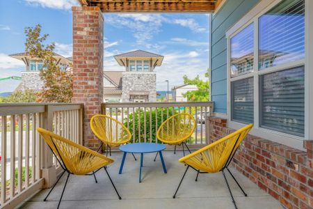 Model apartment outdoor patio with seating facing out at the other buildings in the community
