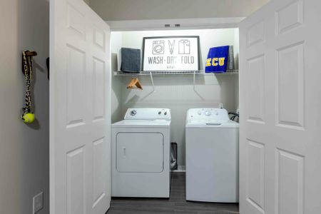 Model apartment laundry room with full size washer and dryer