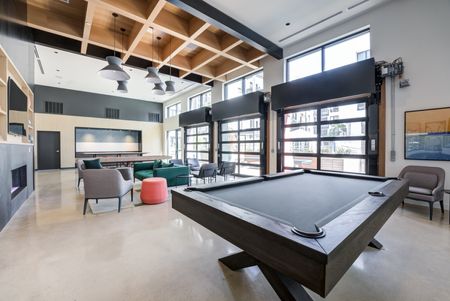 Community clubhouse with games, seating, and a large TV for residents to utilize