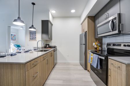 Model apartment kitchen with quartz countertops and stainless steel appliances