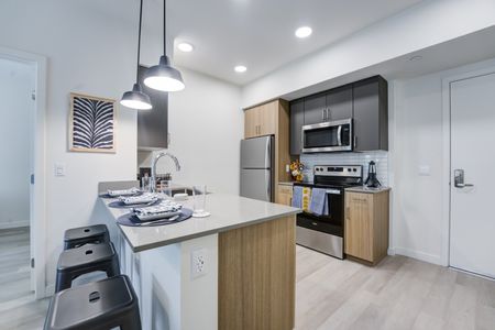 Model apartment kitchen with quartz countertops and stainless steel appliances