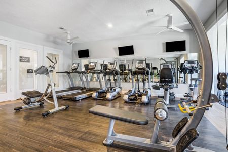 The fitness center at our apartments for rent in Mooresville, NC, featuring wood grain floor paneling and treadmills.
