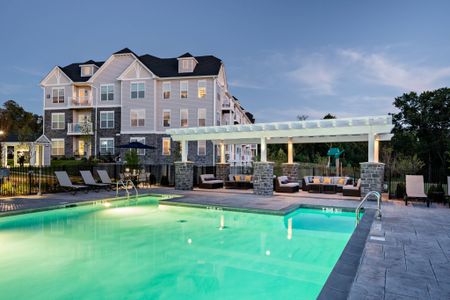 The pool area at our apartments in Ossining at night, featuring beach chairs and a view of the outdoor lounge with umbrellas.