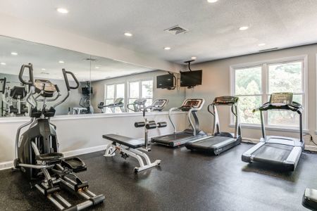 The fitness center at our apartments for rent in Germantown, MD, featuring treadmills, a TV, and a mirrored wall.