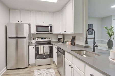 Model kitchen at our apartments for rent in Woodbridge, VA, featuring stainless steel appliances and white cabinetry.