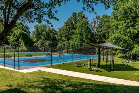 The tennis courts at our apartments for rent in Germantown, featuring an outdoor gym with a shade structure.