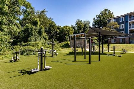 The outdoor gym at our apartments for rent in Germantown, MD, featuring exercise equipment and a shade structure.