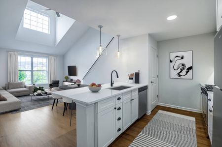 Model kitchen at our apartments in Ossining, featuring wood grain floor paneling and stainless steel appliances.