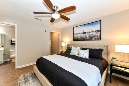 Renovated bedroom with hardwood floor, a large window, and modern furniture in an apartment for rent in Acworth, GA,