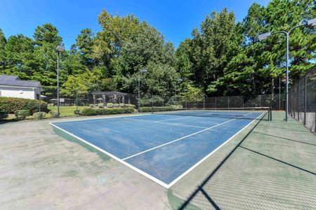 Tennis court surrounded by lush tress at a community with apartments for rent in Acworth, GA.