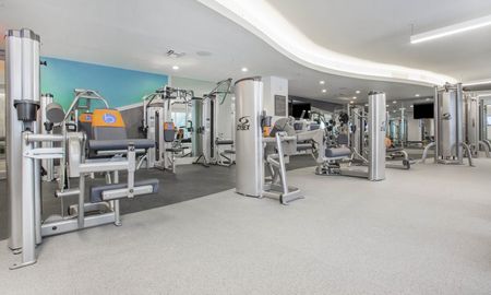 City Walk Apartments fitness center equipped with machines and weights.