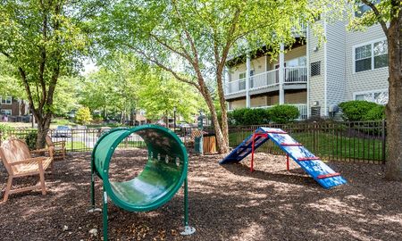 The dog park at our pet friendly apartments for rent in Owings Mills, MD, featuring benches and dog obstacles.