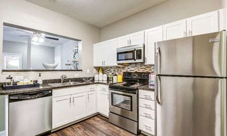 Model kitchen at our apartments for rent in Owings Mills, MD, featuring black counters and stainless steel appliances.