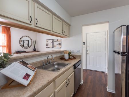Model kitchen at our apartments for rent in Leesburg, VA, featuring wood grain floor paneling and stainless steel appliances.